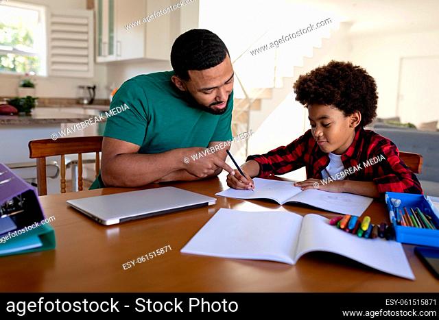 Father helping son with homework at home
