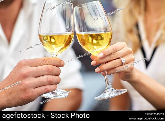 close up of couple clinking wine glasses
