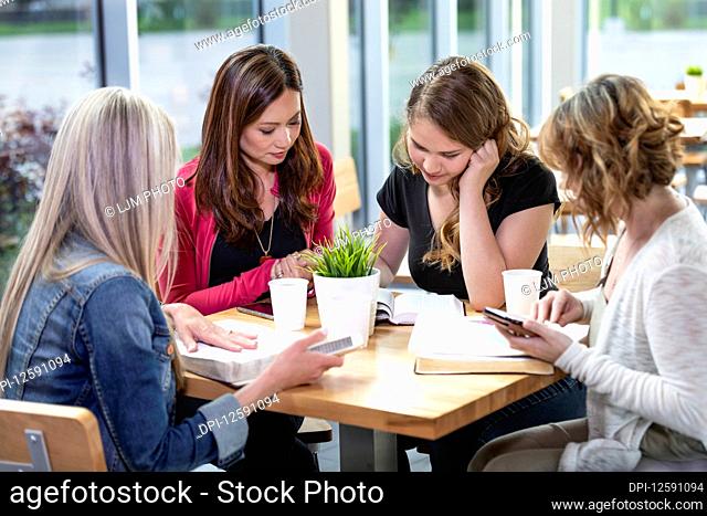 A group of women gathered together for a Bible study in a coffee shop at a church; Edmonton, Alberta, Canada