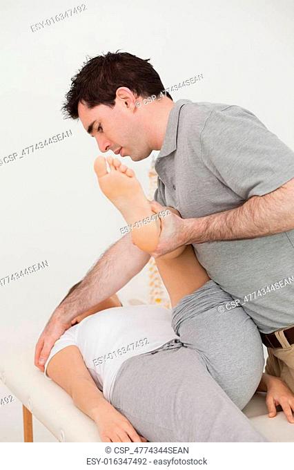 Woman lying while a physio moving her leg
