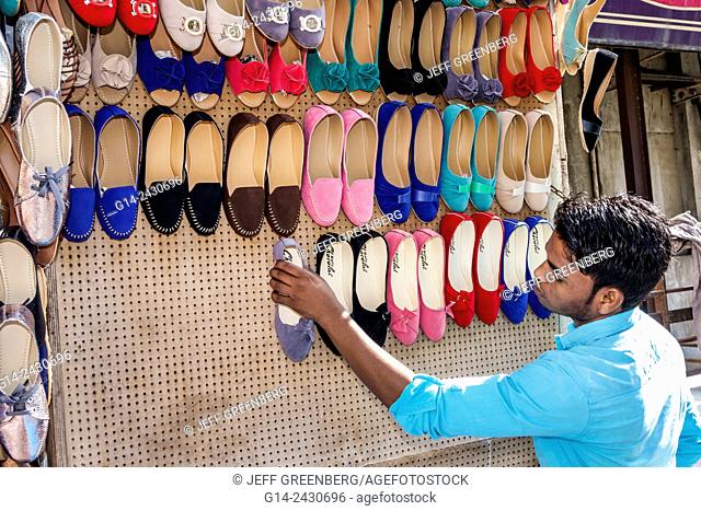 India, Asian, Mumbai, Apollo Bandar, Colaba, Indumati Sakharkar Marg, Causeway, Market, shopping, man, sidewalk vendor, woman's, shoes, setting up shop, sale