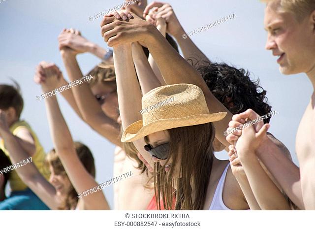 Portrait of pretty young lady in hat and sunglasses surrounded by friends