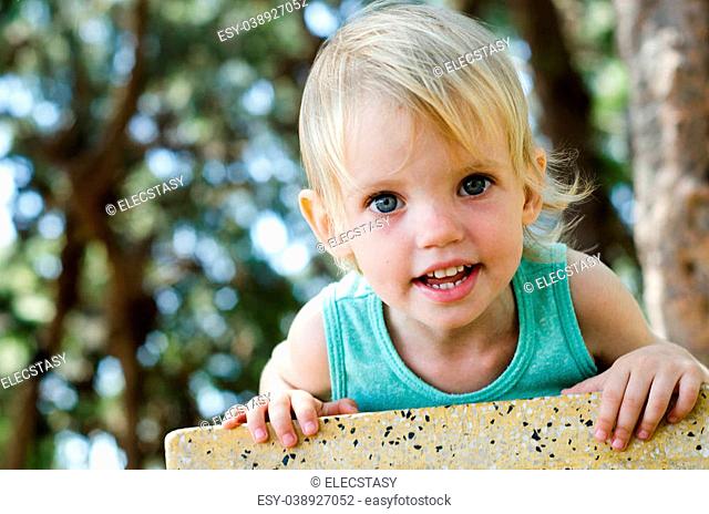 Adorable smiling toddler girl looking right in camera shallow focus