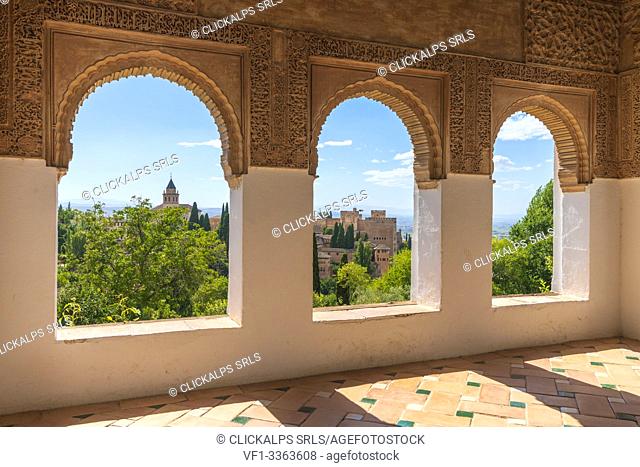 Gardens of Generalife seen from interior room of palace with arabic archways and decorated tiled floor, La Alhambra complex, Granada, Andalusia, Spain