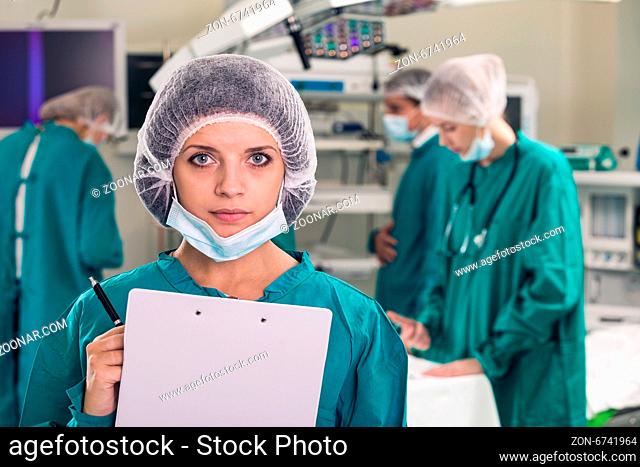 Portrait of surgeons in surgery with doctors working on background