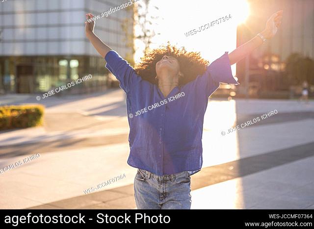 Woman with arms raised on sunny day