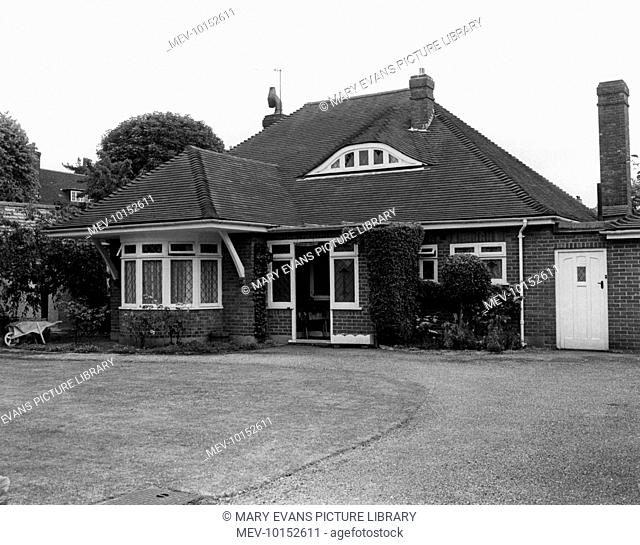 A detached dormer bungalow with a rather featureless front garden