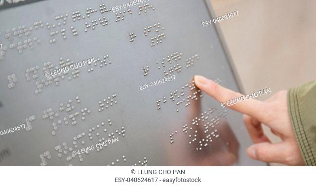 Blind reading on Braille at outdoor directory