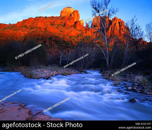 Warm light of sunset illuminating Cathedral Rock beyond Oak Creek swollen with spring snow melt, Red Rock Crossing, Coconino National Forest, Arizona
