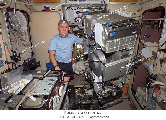 Astronaut John L. Phillips, Expedition 11 NASA ISS science officer and flight engineer, poses for a photo with the Treadmill Vibration Isolation System (TVIS)...