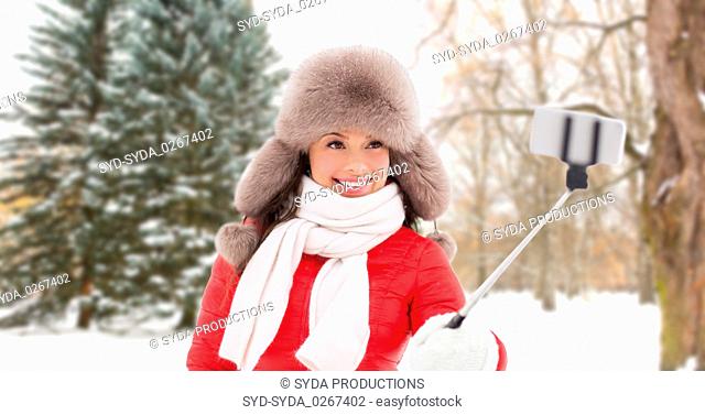 happy woman taking selfie over winter forest