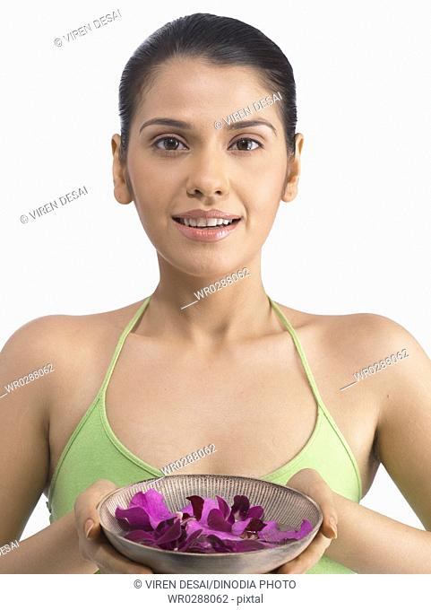 South Asian Indian woman offering petals of mokara orchid flower wearing green dress MR 702