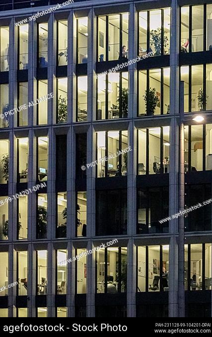 27 November 2023, Saxony, Leipzig: The offices in a building in the city center are brightly lit in the evening. Photo: Jan Woitas/dpa