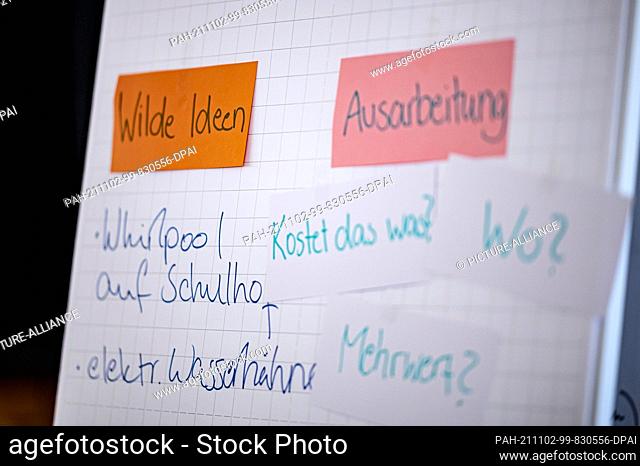 PRODUCTION - 27 October 2021, Berlin: On a sheet of paper on a flip chart, there are various terms used in a workshop on democratic participation