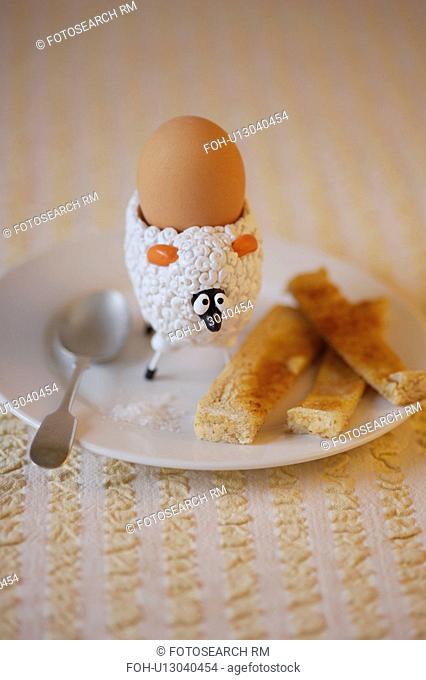 Childrens sheep egg cup with boiled egg and buttered soldiers