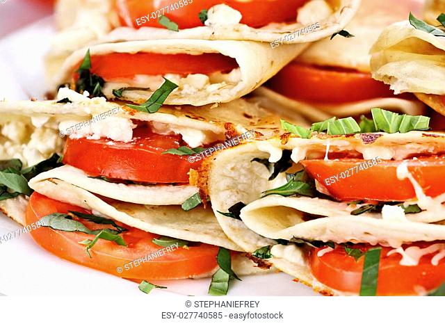 Vegetarian wraps made with goat cheese or feta, tomatoes, mozzarella and fresh herbs, Extreme shallow depth of field