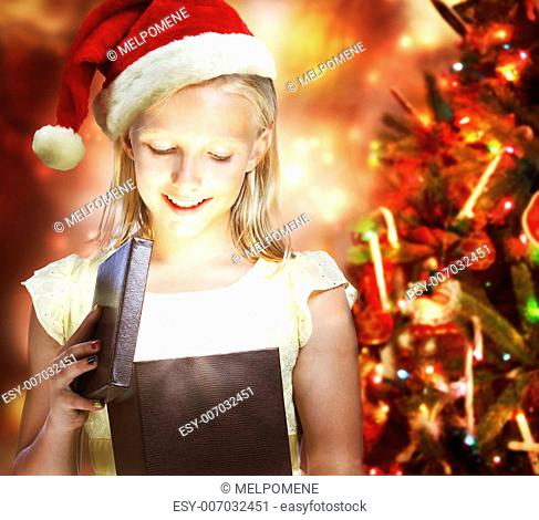 Happy Blonde Girl with Santa Hat Opening a Gift Box