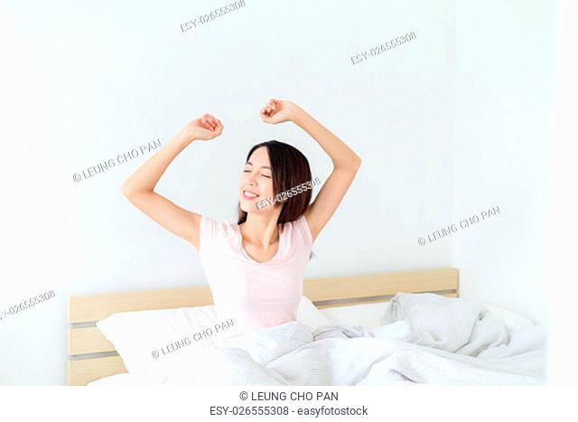 Woman waking up and yawning with a stretch