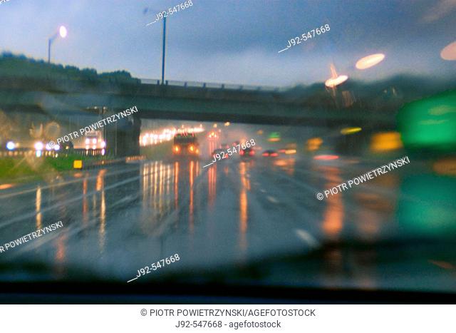 Cars driving along wet road at dusk 2006. New Jersey Turnpike, USA