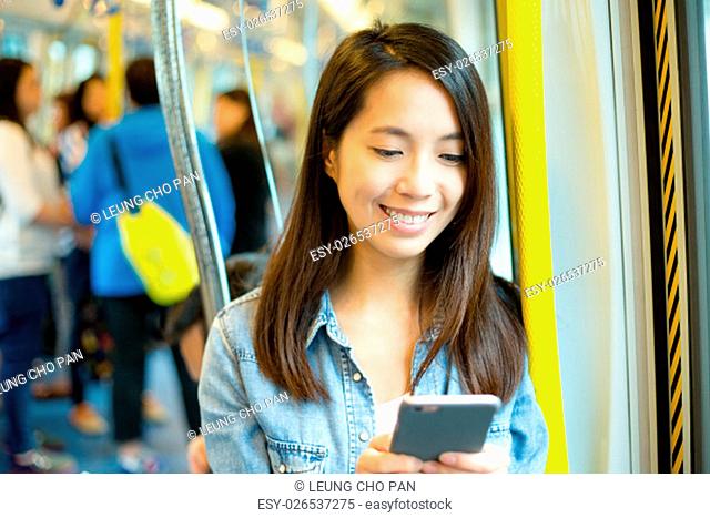 Woman using cellphone in train compartment