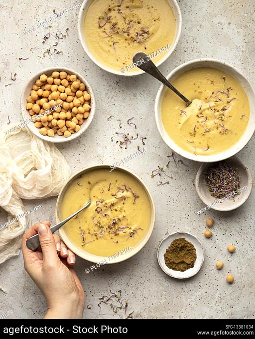 Chickpea cream soup with cumin, chickpeas, ground cumin and baby kale
