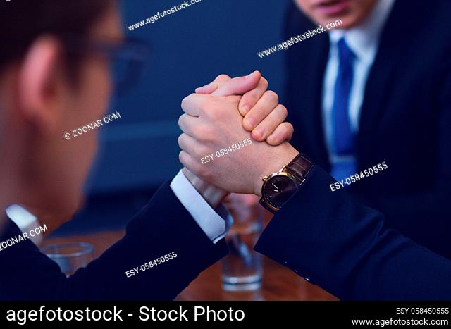 Two businessmen compete in armwrestling after conference. Showing business power