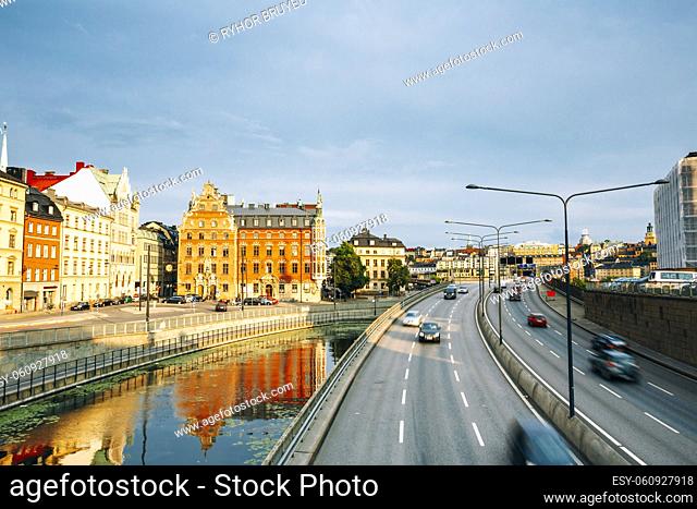 Stockholm, Sweden. The View Of Embankment And Centralbron Highway With Moving Cars In Gamla Stan In Summer Sunny Evening Day