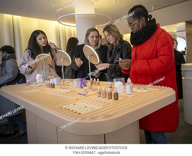 Millennials trying on makeup crowd the Glossier brick-and-mortar store in Soho in New York on Wednesday, March 20, 2019. Glossier