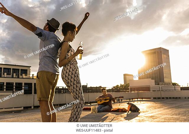 Young couple dancing on a rooftop party