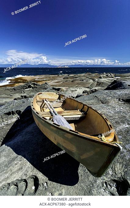 An abandoned dory comes to rest on sandstone rock formations on the Northern tip of Gabriola Island. Garbriola Island, Gulf Islands, British Columbia, Canada