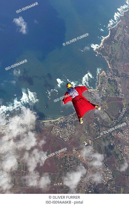 Woman in wingsuit flying above Honolulu, Hawaii