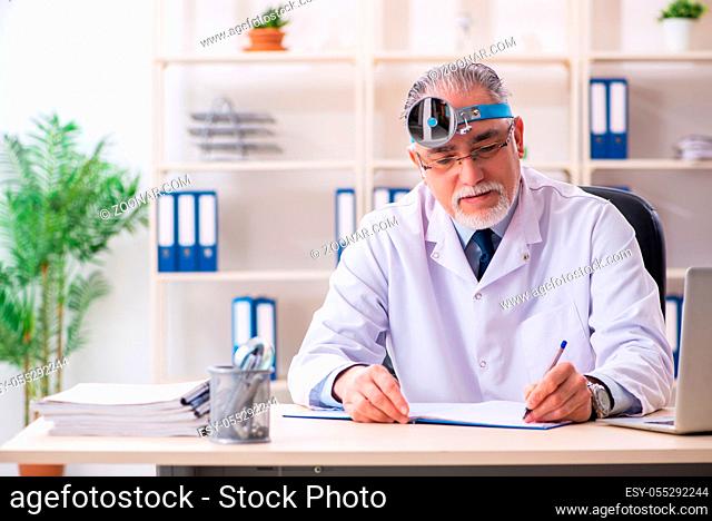 Aged male doctor laryngologist working in the clinic