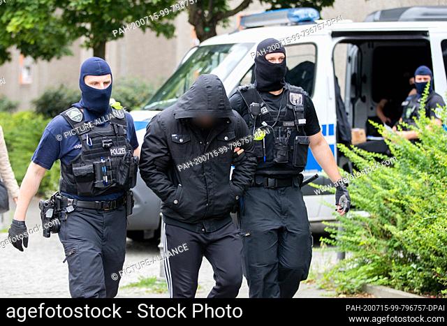 15 July 2020, Berlin: A man is taken away by two policemen during a police operation as part of a large-scale raid against suspects from the Islamist scene in...
