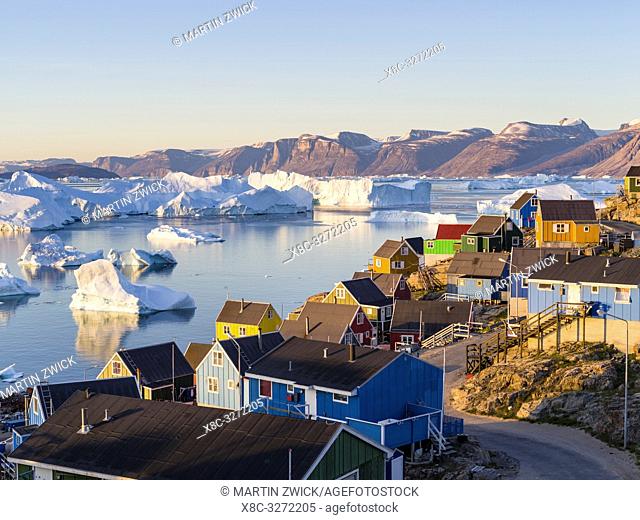 View of fjord full of icebergs towards Nuussuaq (Nugssuaq) peninsula during midnight sun. The town Uummannaq in the north of West Greenland