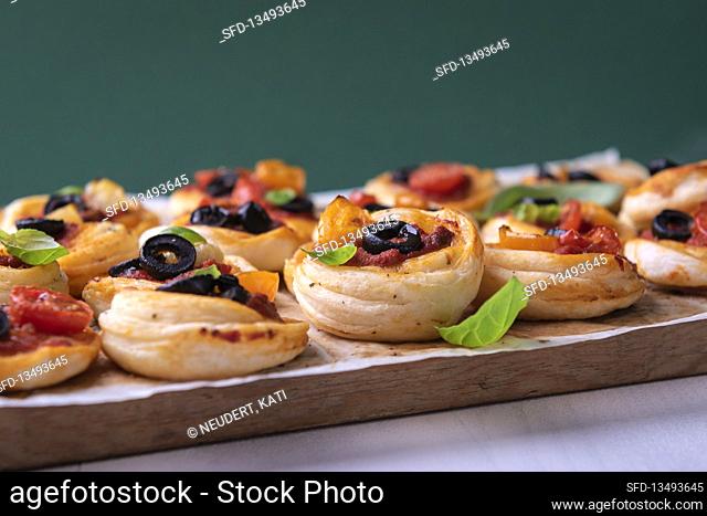 Vegan puff pastry spirals with tomatoes, olives and basil