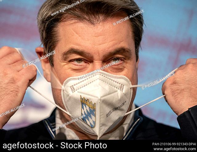 06 January 2021, Berlin: Markus Söder (CSU), Prime Minister of Bavaria and CSU chairman, puts on his mask during the press conference at the winter retreat of...