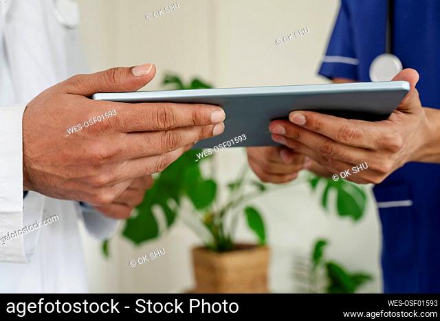 Doctors checking tablet PC at healthcare clinic