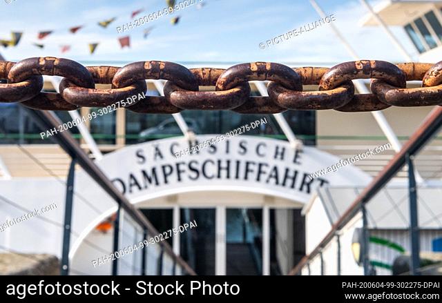 03 June 2020, Saxony, Dresden: A chain hangs in front of a landing stage of the Sächsische Dampfschiffahrt on the terrace bank