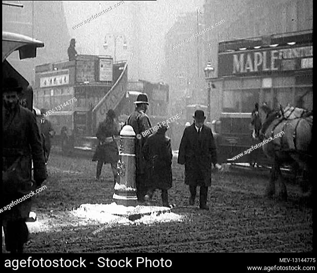 British Civilians Going About their Daily Commute on a Snowy Day on the Streets Watched By A Male British Police Officer With Buses And Cars at the Background -...