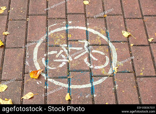White painted bicycle traffic sign. City stone pavement