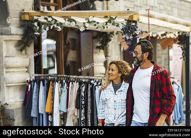 Couple shopping on city street. Couple embracing while walking on city street. Happy couple enjoying while roaming around streets