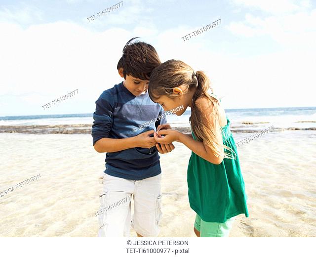 Portrait of girl (6-7) and boy (10-11) on beach