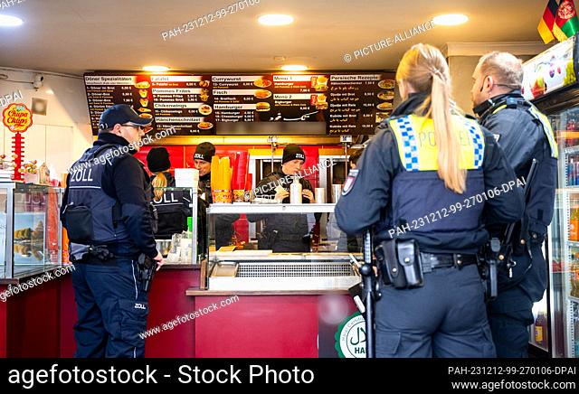 12 December 2023, Hamburg: Police, customs and authorities officers stand in a snack bar in the Rothenburgsort district of Billstraße