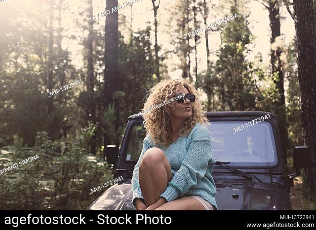 Cheerful happy lady enjoy freedom traveling by car in the forest - woman people in the woods alternative lifestyle in nature outdoor park leisure activity...