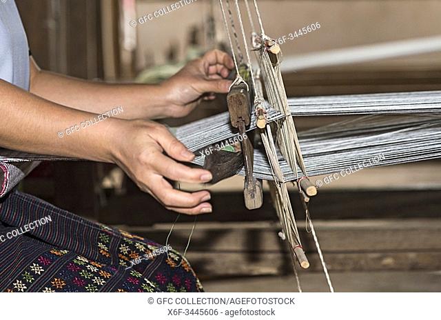 Weaving with a shuttle on a traditional Lao-Thai style loom, Ban Phanom, Laos