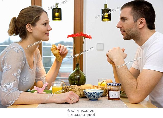 Young couple staring at each other over breakfast