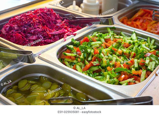 Assortment of fresh vegetable salads and colorful spicy pickles on the traditional food stand selling shawarma sandwiches and other grilled meats in the Old...