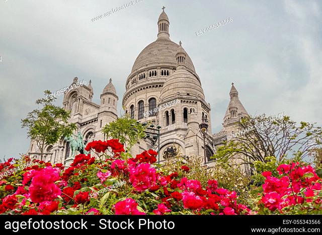 France, Paris. Cloudy evening near the Cathedral Sacre-Coeur. Red roses in the foreground