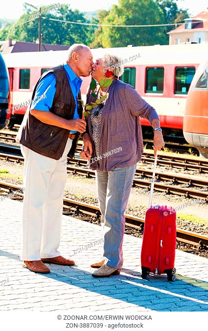 Älteres vitales Senioren Paar am Bahnhof. Reisen in den Urlaub