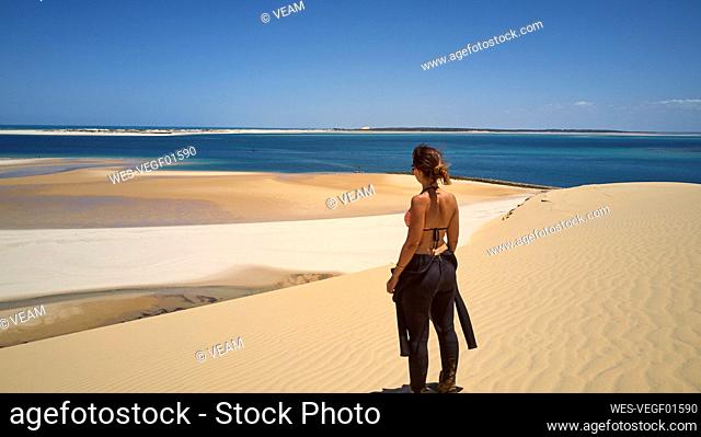 Mozambique, Bazaruto archipelago, Woman in a diving suit at Bazaruto dunes and the Indic ocean